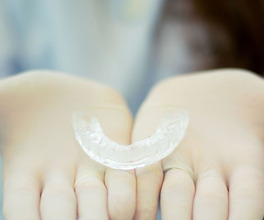 Gloved hands presenting a clear custom retainer
